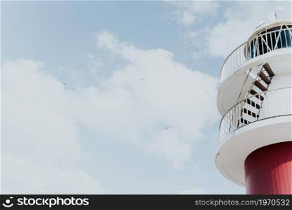Wallpaper of a red and white lighthouse with copy space and seagulls flying, minimalistic, inspiration concept freedom