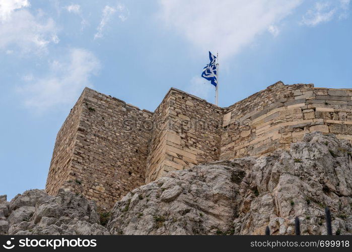 Walls of Acropolis rise above Anafiotika in Athens by the Acropolis. Acropolis rises above district of Anafiotika in Athens Greece