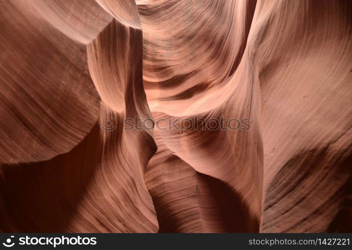 Walls of red rock canyon with a flowing pattern on them.