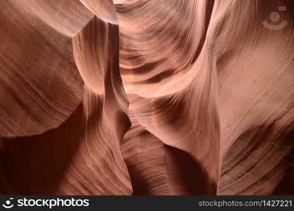 Walls of red rock canyon with a flowing pattern on them.