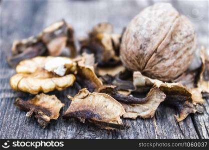 Walnut kernels and partitions near whole walnuts on a wooden table. The medicine for tinctures and decoctions. walnuts. Walnut kernels and partitions near whole walnuts on a wooden table. The medicine for tinctures and decoctions.