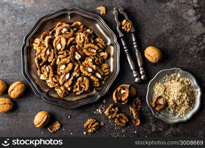 Walnut kernels and whole walnuts on rustic old wooden table