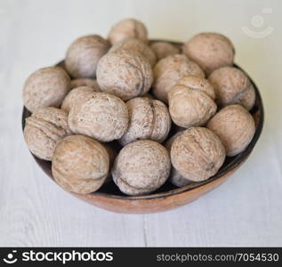 walnuts in a bowl on a wooden table