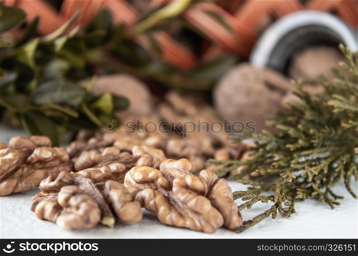 Walnuts on a white table, walnut kernels. Healthy food from walnut. Walnuts in a basket with a vine.. Walnuts on a white table, walnut kernels. Healthy food from walnut. Walnuts in the basket.