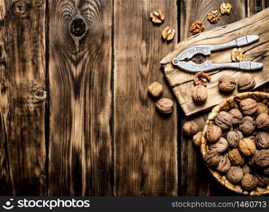 Walnuts with Nutcracker on the Board. On a wooden table.. Walnuts with Nutcracker on the Board.