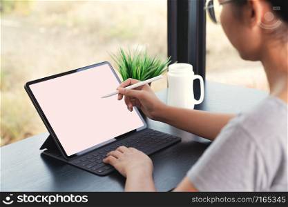 waman using digital tablet with stylus pen and smart keyboard