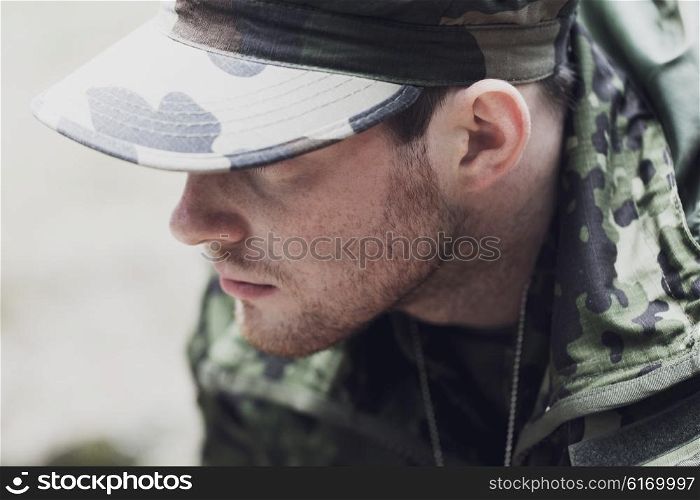 war, army and people concept - close up of young soldier in military uniform