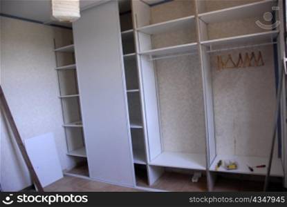 wardrobe in construction with clothes hangers and screwdrivers