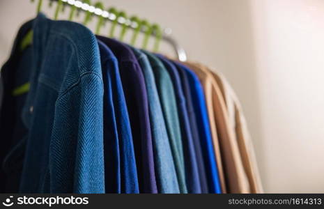 Wardrobe Rack. Men Clothes hanging on Bar by the White Wall. Fashion Lifestyle of a Stylish Man