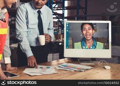 Warehouse staff talking on video call at computer screen in storage warehouse . Online software technology connects people working in logistic factory by virtual conference call on internet network .