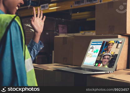 Warehouse staff talking on video call at computer screen in storage warehouse . Online software technology connects people working in logistic factory by virtual conference call on internet network .. Warehouse staff talking on video call at computer screen in storage warehouse