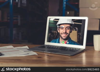 Warehouse staff talking on video call at computer screen in storage warehouse . Online software technology connects people working in logistic factory by virtual conference call on internet network .. Warehouse staff talking on video call at computer screen in storage warehouse