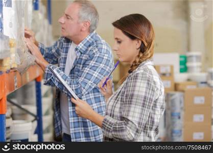 warehouse storage worker checking stock products for shipping to customer