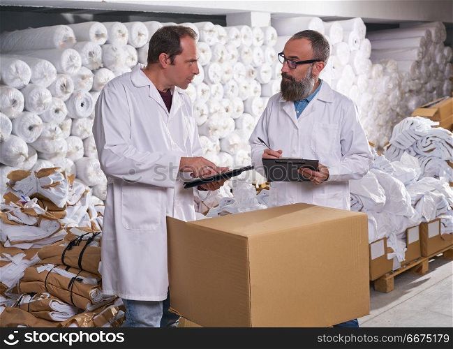 warehouse supervisor and manager men with textile. warehouse supervisor and manager men in fashion textile factory