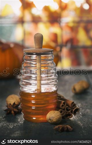 Warm and comfy autumn composition. Jar of Honey, pumpkins and spices on wooden window sill. Fall autumn harvest concept.