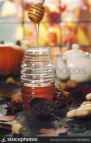 Warm and comfy autumn concept. Jar of Honey, pumpkins, spices and tea on wooden window sill. Warm and comfy autumn composition. Jar of Honey, pumpkins and spices on wooden window sill. Fall autumn harvest concept.