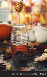 Warm and comfy autumn concept. Jar of Honey, pumpkins, spices and tea on wooden window sill. Warm and comfy autumn composition. Jar of Honey, pumpkins and spices on wooden window sill. Fall autumn harvest concept.