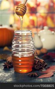 Warm and comfy autumn concept. Jar of Honey, pumpkins, spices and tea on wooden window sill. Warm and comfy autumn composition. Jar of Honey, pumpkins and spices on wooden window sill. Fall autumn harvest concept.. Autumn composition with honey. Warm and comfy autumn concept.