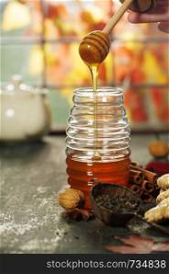 Warm and comfy autumn concept. Jar of Honey, pumpkins, spices and tea on wooden window sill. Warm and comfy autumn composition. Jar of Honey, pumpkins and spices on wooden window sill. Fall autumn harvest concept.. Autumn composition with honey. Warm and comfy autumn concept.