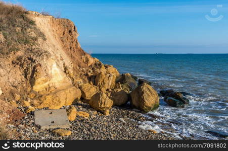 Warm late autumn day on the seashore near the village of Fontanka, Odessa region, Ukraine. Rock on the edge of the Black Sea