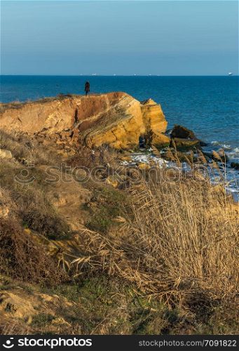 Warm late autumn day on the seashore near the village of Fontanka, Odessa region, Ukraine. Rock on the edge of the Black Sea