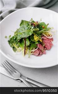 warm meat salad on white plate