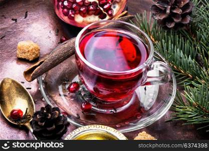 warm pomegranate tea.. Cup of tea with pomegranate on retro rustic background