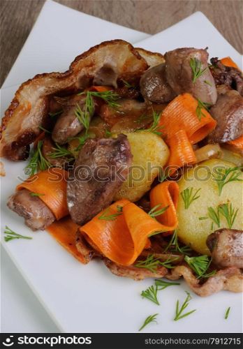 Warm salad with carrots, onions, potatoes sauteed chicken hearts and bacon