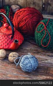Warm winter tea. Balls of wool for knitting and stylish red kettle