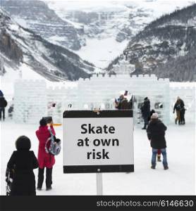 Warning signboard with people at ski resort, Lake Louise, Banff National Park, Alberta, Canada