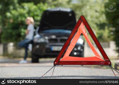 warning triangle behind his broken car