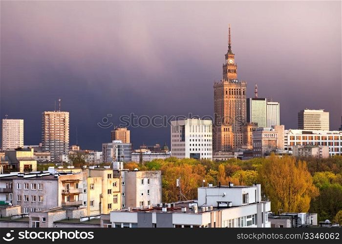 Warsaw, capital city of Poland, featuring Palace of Culture and Science, Srodmiescie district. Sunset time, stormy sky.