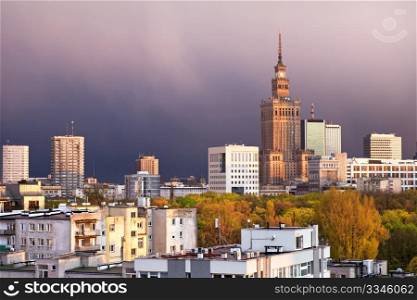 Warsaw, capital city of Poland, featuring Palace of Culture and Science, Srodmiescie district. Sunset time, stormy sky.