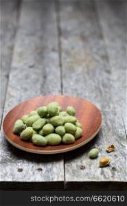 Wasabi peanuts on rustic wooden background.. Wasabi peanuts on rustic wooden background