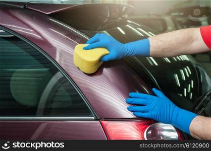 washing car with sponge. hand with sponge over the car for washing