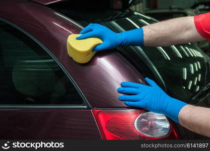 washing car with sponge. hand with sponge over the car for washing