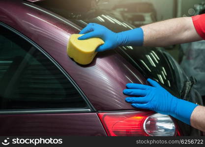 washing car with sponge. hand with sponge over the car for washing