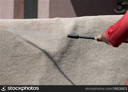 Washing carpets with high pressure washer. Cleaning the carpet with a gun for washing high pressure water