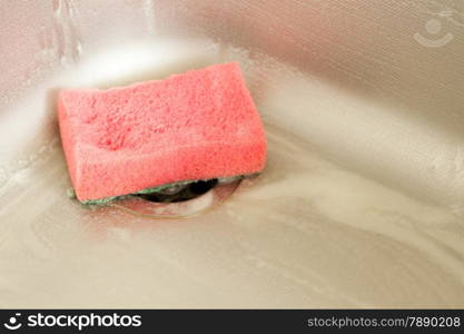 Washing dishes. Closeup of kitchen sink with foam sponge. Housework. Real.