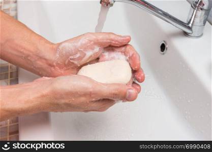 Washing hands with soap in the sink