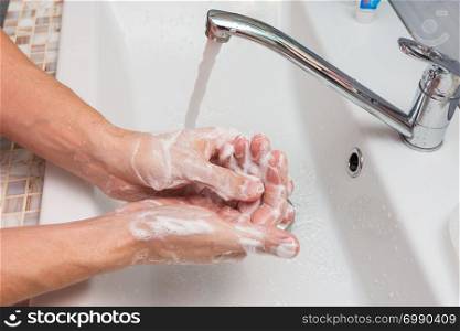 Washing hands with soap in the sink