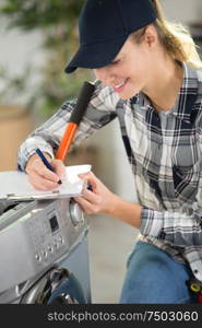 washing machine female technician writes on folder diagnostics