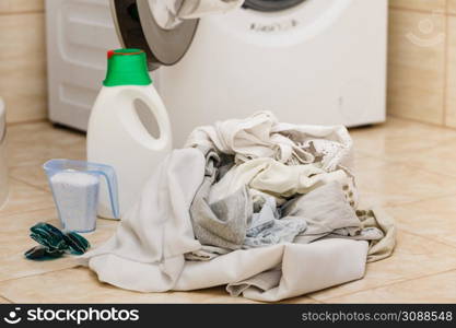 Washing powder detergent and measuring cup next to machine in bathroom. Household duties, clothes laundry obejcts concept.. Laundry washing powder detergent