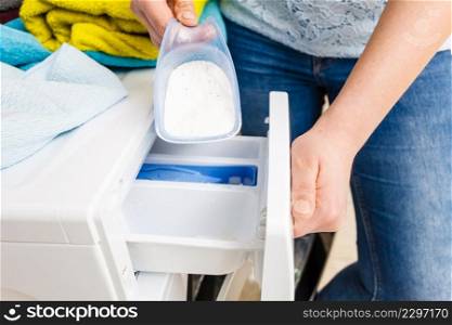 Washing powder detergent and measuring cup pouring into machine. Household duties, clothes laundry obejcts concept.. Laundry washing powder detergent