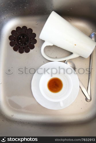 Washing up. White coffee cups in the kitchen sink.