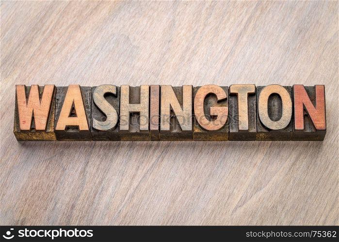 Washington word abstract in vintage letterpress wood type against grained wooden background