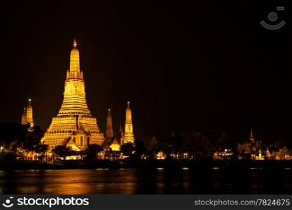 Wat Arun at night. The pagoda is a light yellow-orange.