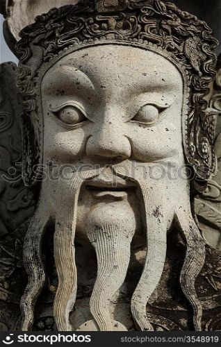 Wat Pho Chinese stone guardian face close up, Bangkok, Thailand