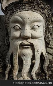 Wat Pho Chinese stone guardian face close up, Bangkok, Thailand