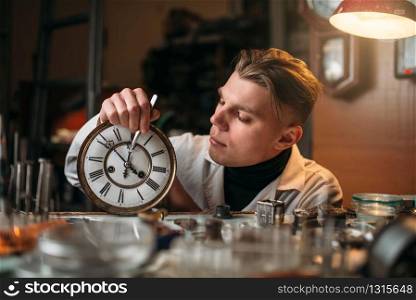 Watchmaker adjusts the mechanism of old watches in the workshop. Clock maker at work